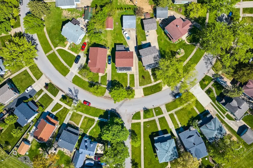 Bird's eye view of half-circle suburban street with large homes.